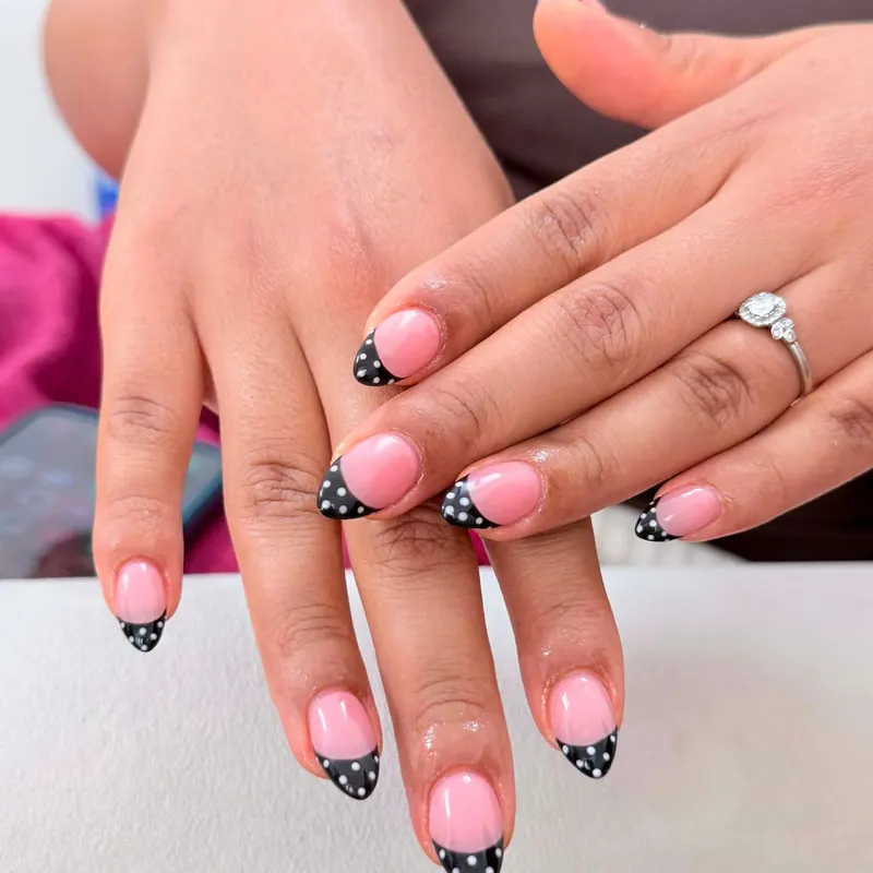 Pink nails with black polka dot French tips by LENA Nails & Beauty, nail salon in Da Nang