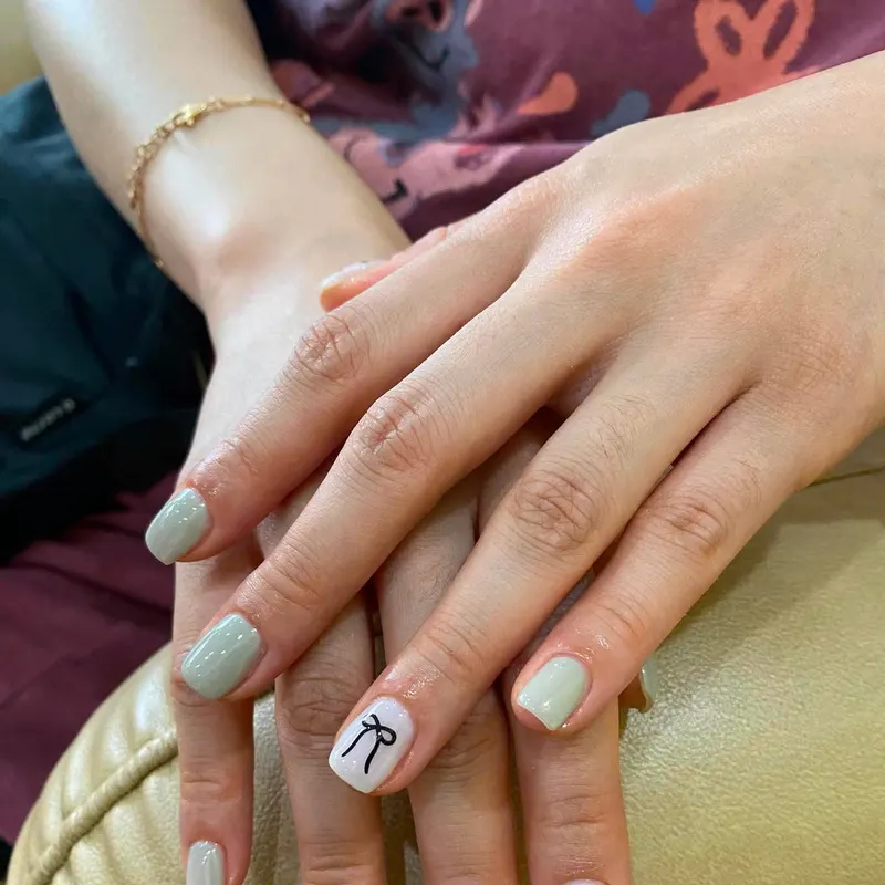Sage green nails with bow and polka dot art by LENA Nails & Beauty, nail salon in Da Nang
